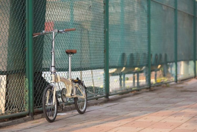 Folding bike by fence